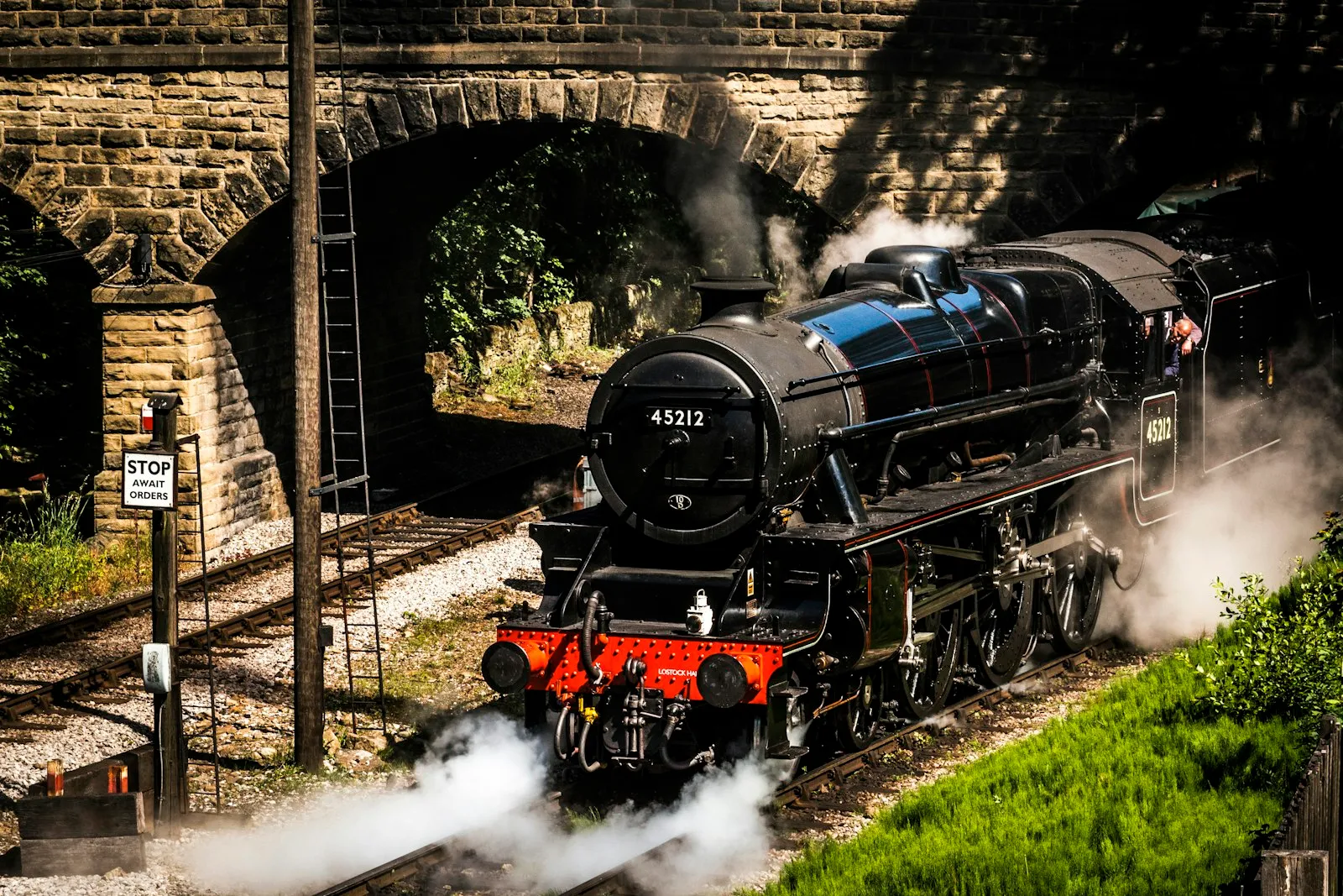 LONDON MIDLAND & SCOTTISH RAILWAY CLASS 5MT 45212 steam train departs Haworth station travelling under the bridge at Bridgehouse Lane.