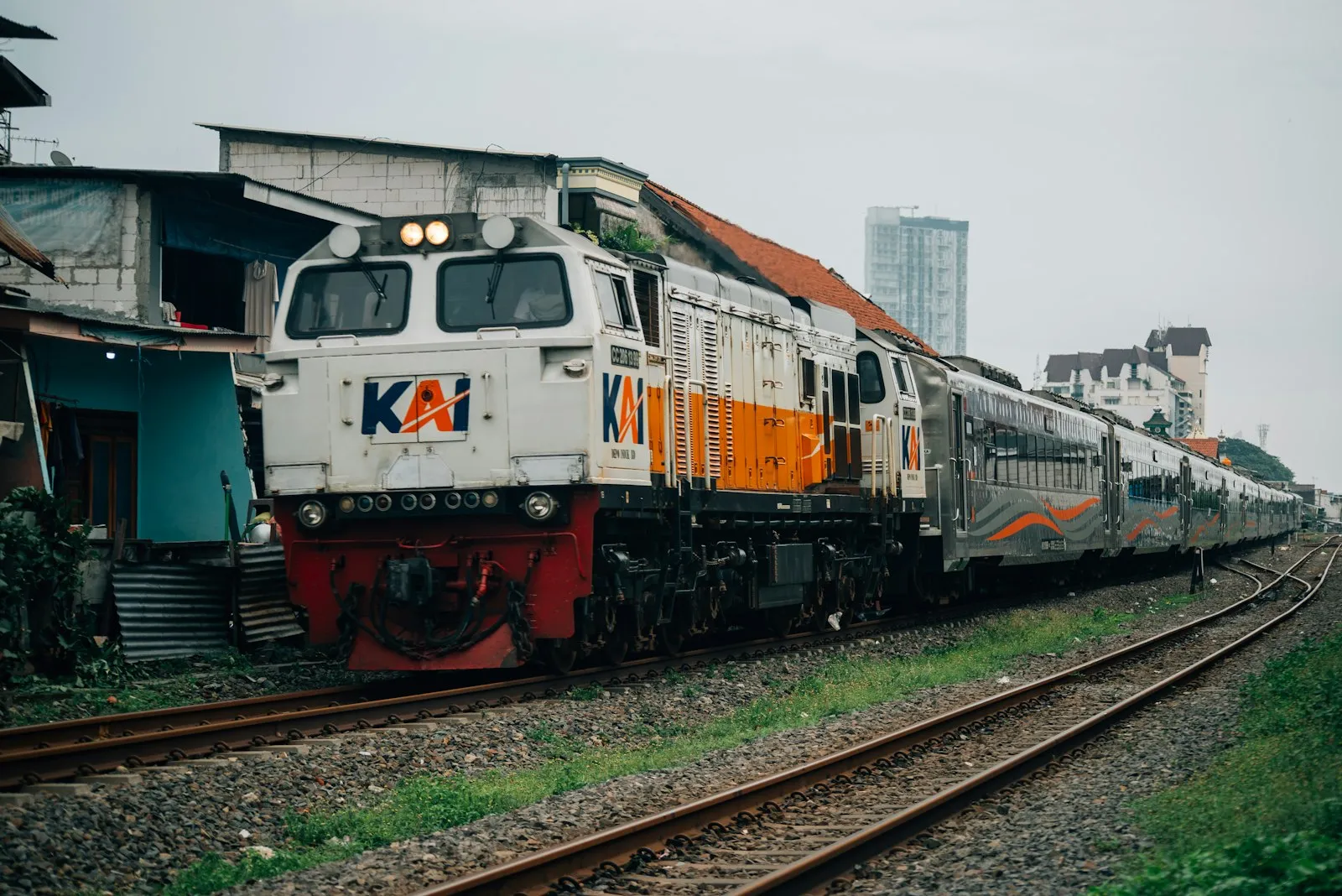 A CC206 / GE CM20EMP locomotive pulling the Argo Wilis consist bound to Bandung speeding down the track near the Wonokromo train station