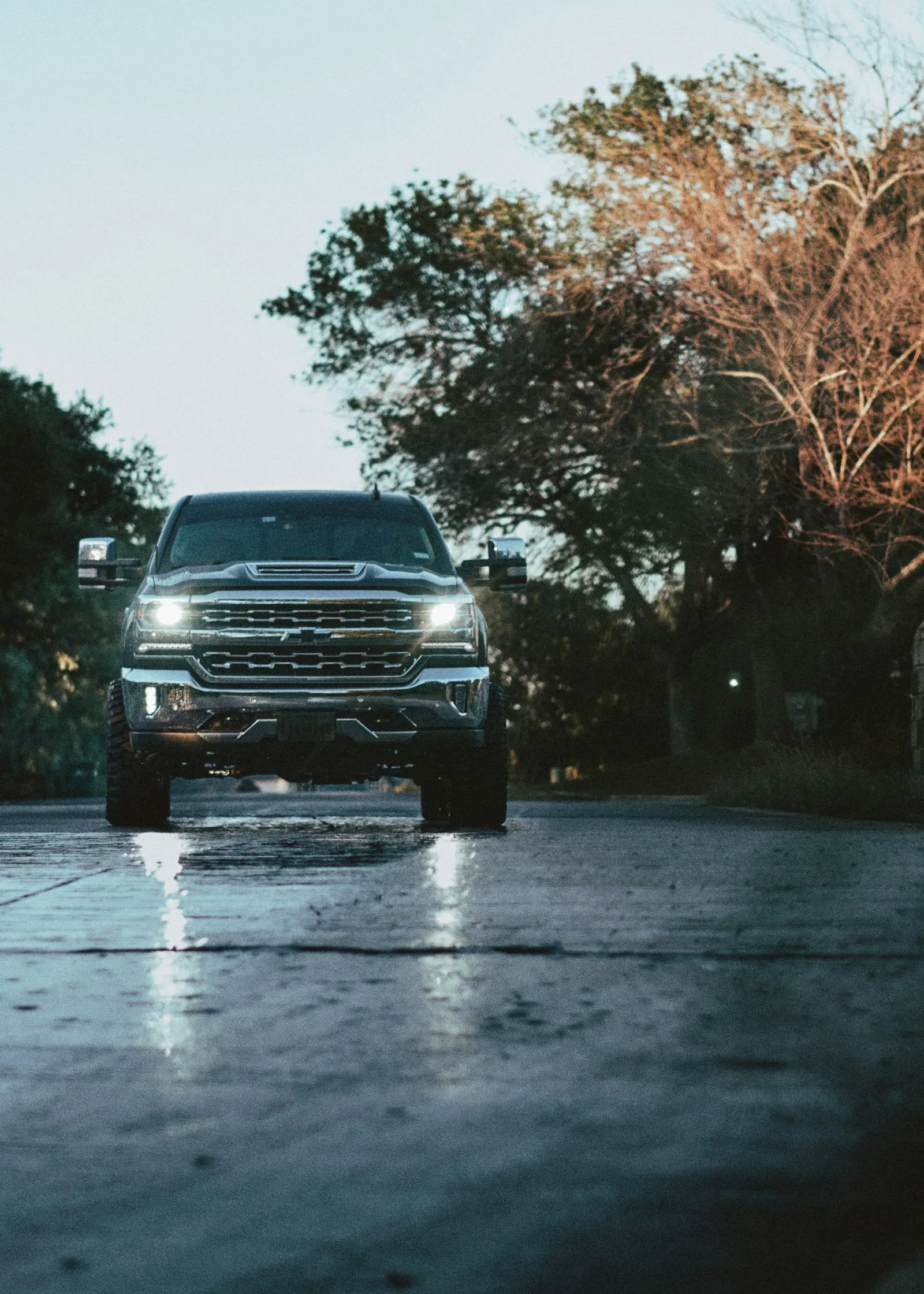 Chevrolet Silverado driving on a wet road — Silverado install context (T1 platform secondary battery tray fits Vixen 0.5-gal kits)