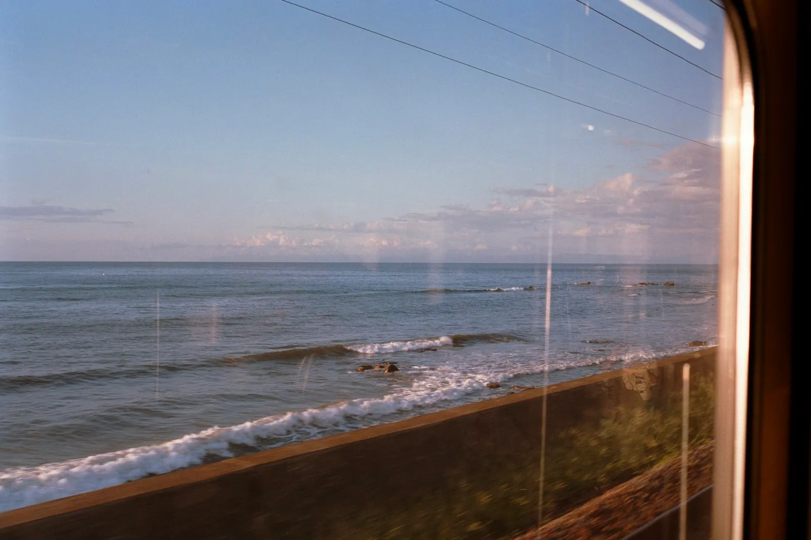 Ocean view from a train window — LOSSAN coastal corridor where San Diego sits at the southern terminus