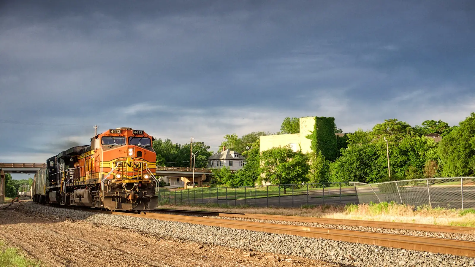 Bright orange train on the rails — colorful budget-tier visual matching the Vevor 4-Trumpet kit's price-vs-loudness vibe