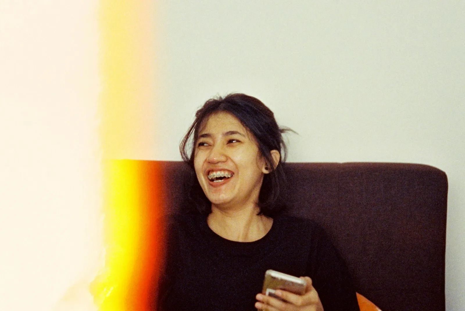 Person laughing while holding a phone — the social-media reaction culture around train horn pranks