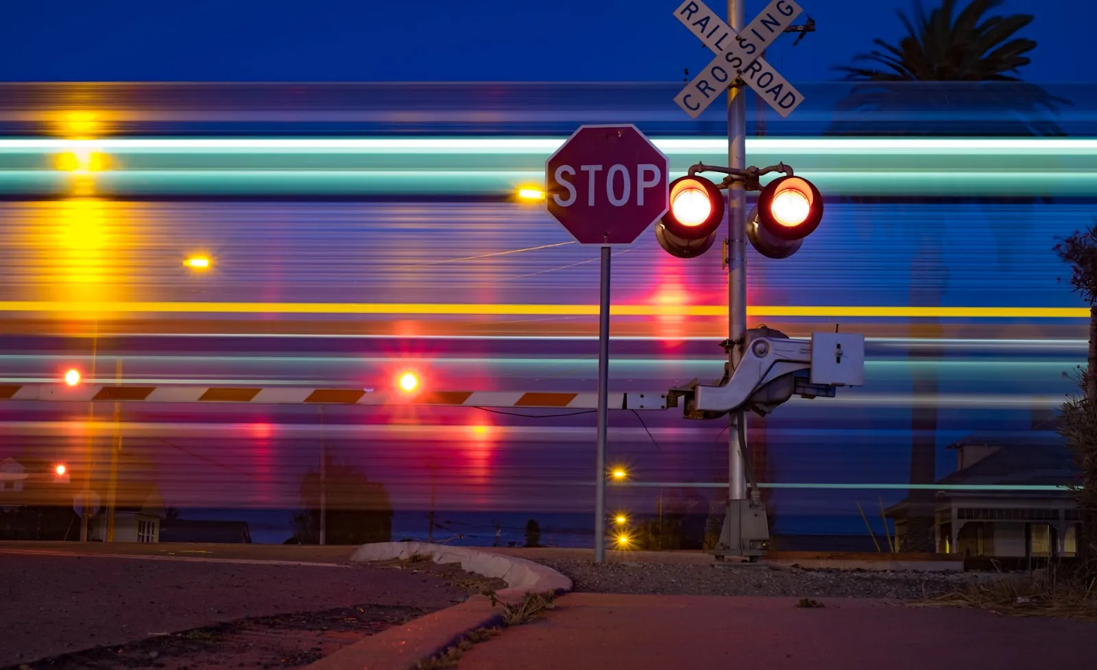 Railroad crossing stop sign at night — the generic locomotive horn at every public grade crossing