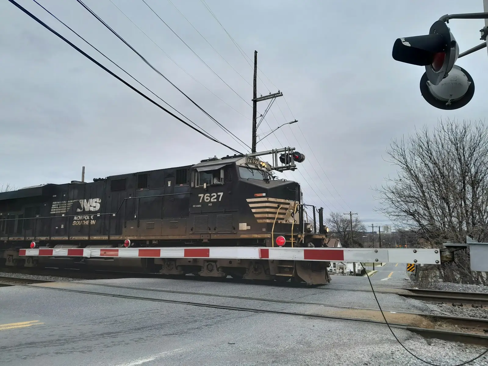 A train traveling down train tracks next to a traffic light