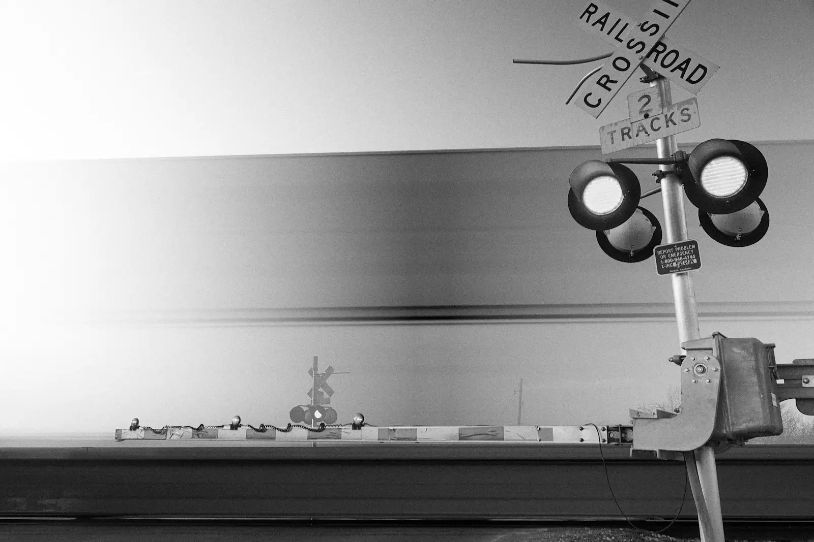 A black and white railroad crossing signal