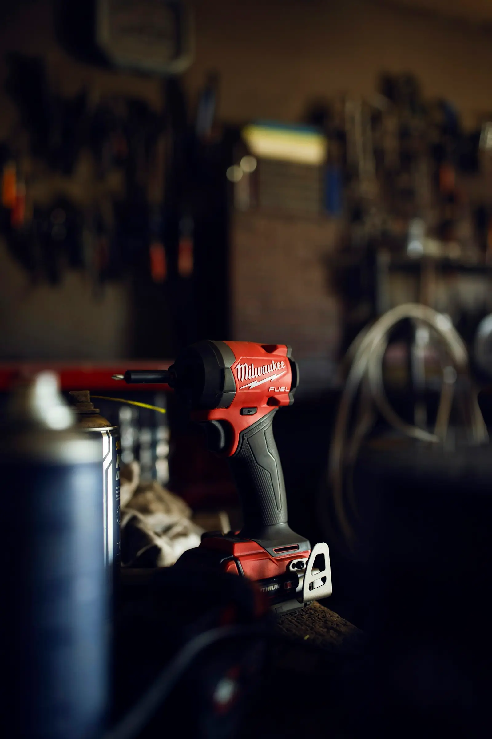 Red cordless impact driver on a workbench — Milwaukee M18 platform context for portable train horn battery integration