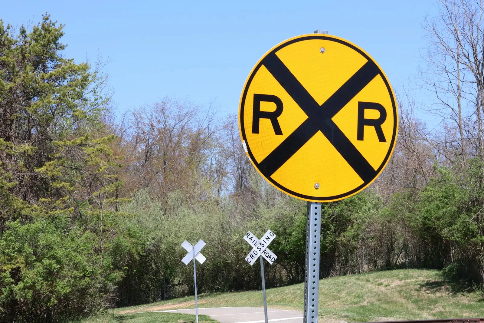 A railroad crossing sign on the side of the road