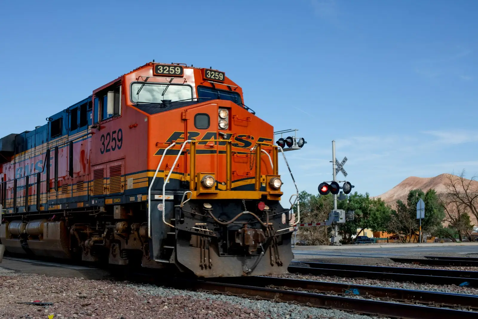 An orange and blue train on railroad tracks