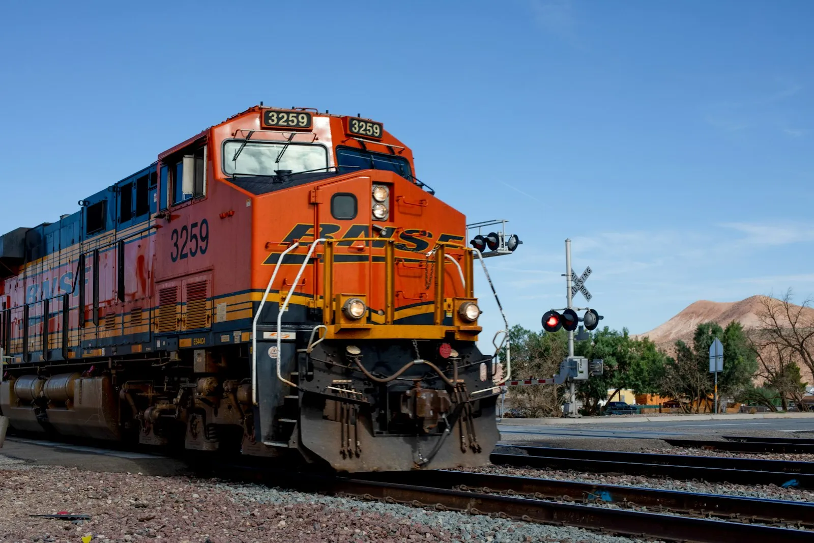 An orange and blue train on railroad tracks