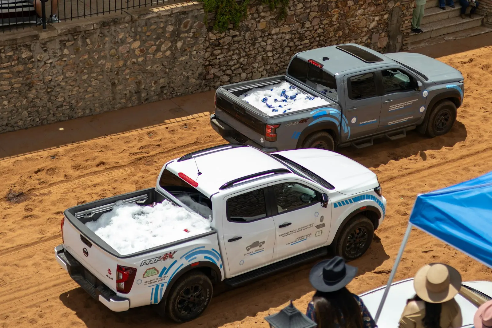 Two pickup trucks parked at an event — Nissan Frontier mid-size install context
