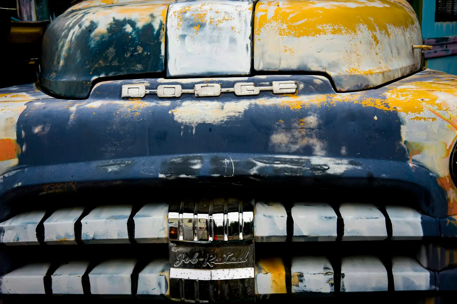 Rusty, weathered front of an old car with peeling paint