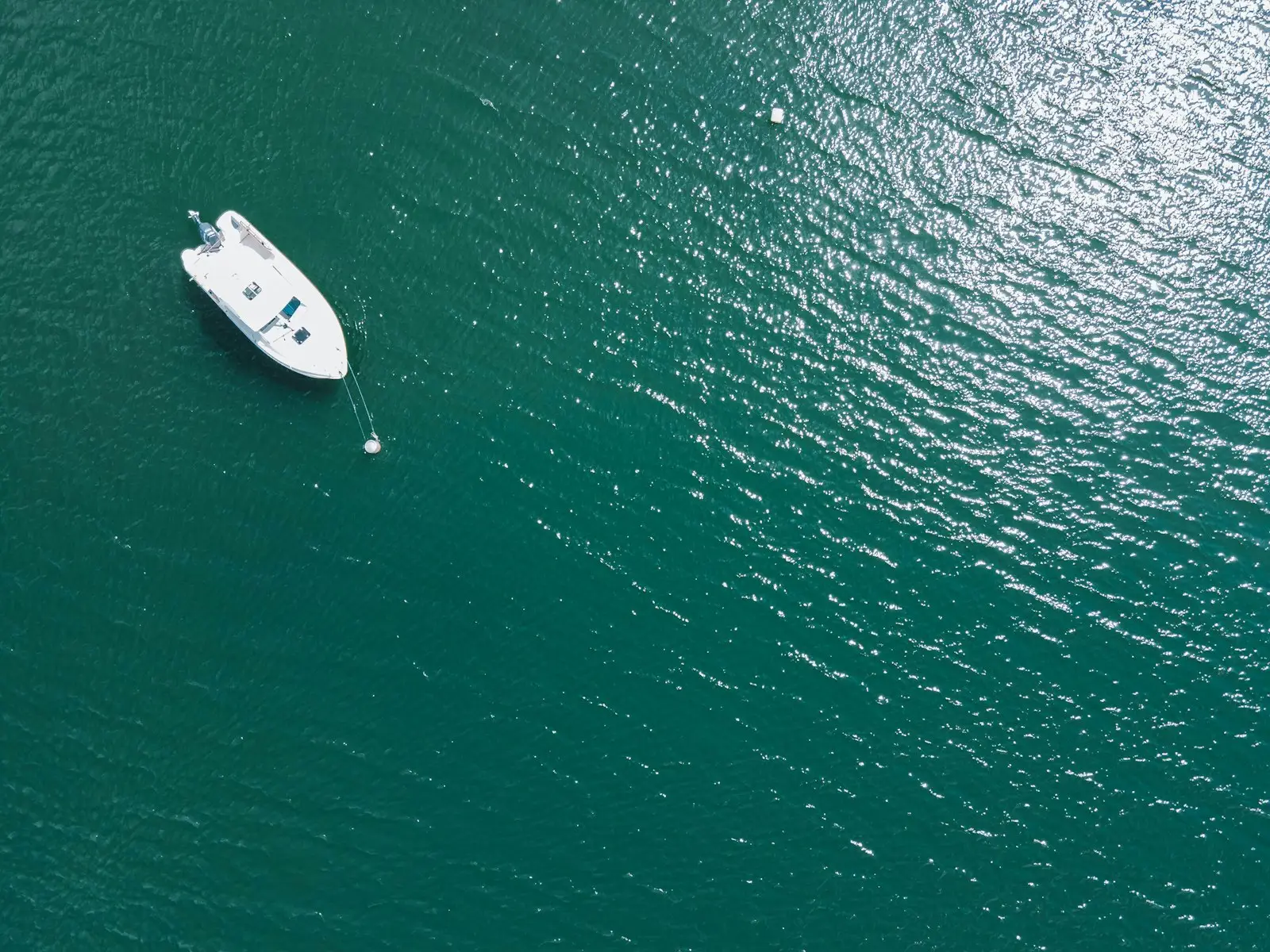 A small boat floating on top of a large body of water