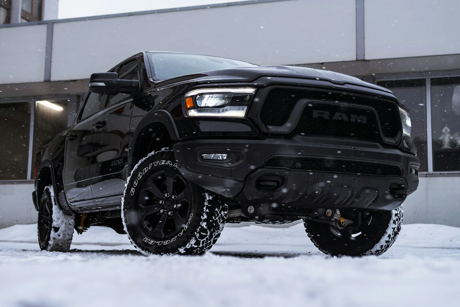 Black Ram pickup in front of a building — Ram 1500 install context