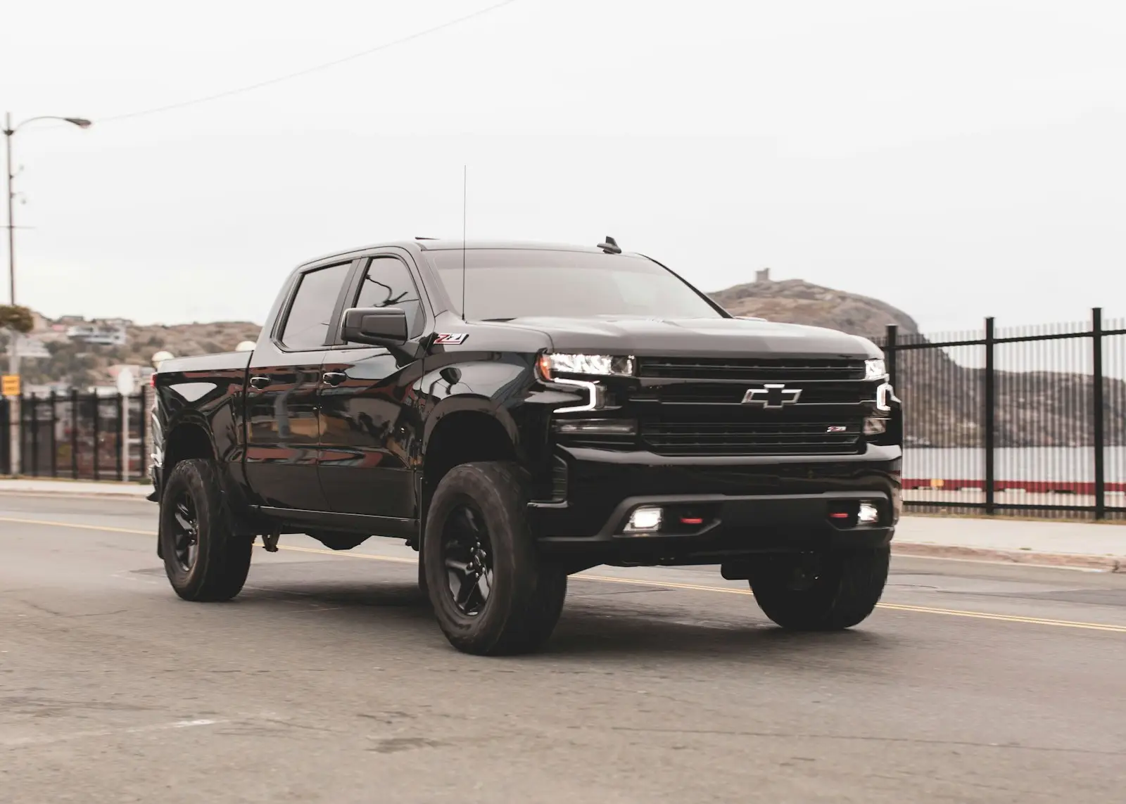 Black chevrolet single cab pickup truck on gray sand during daytime