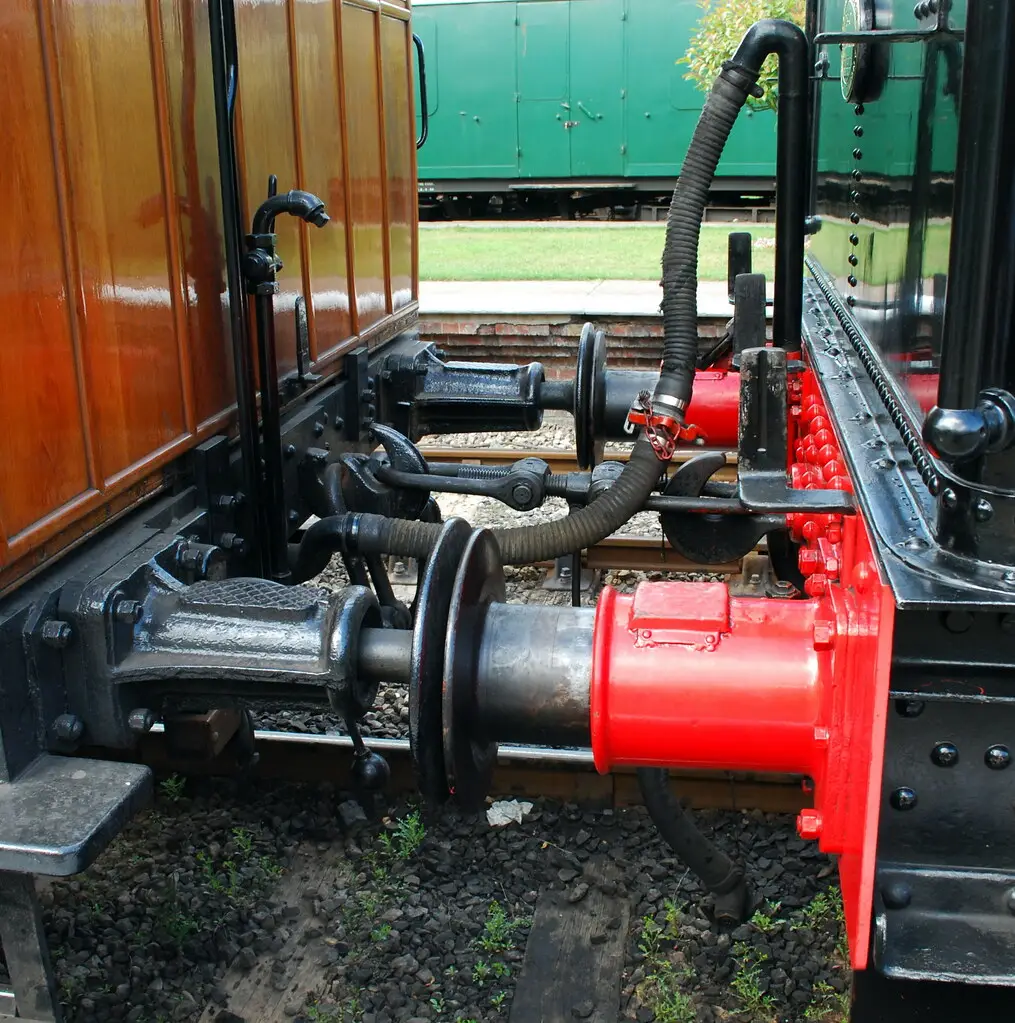 Close-up of coupled train brake air hoses between rail cars