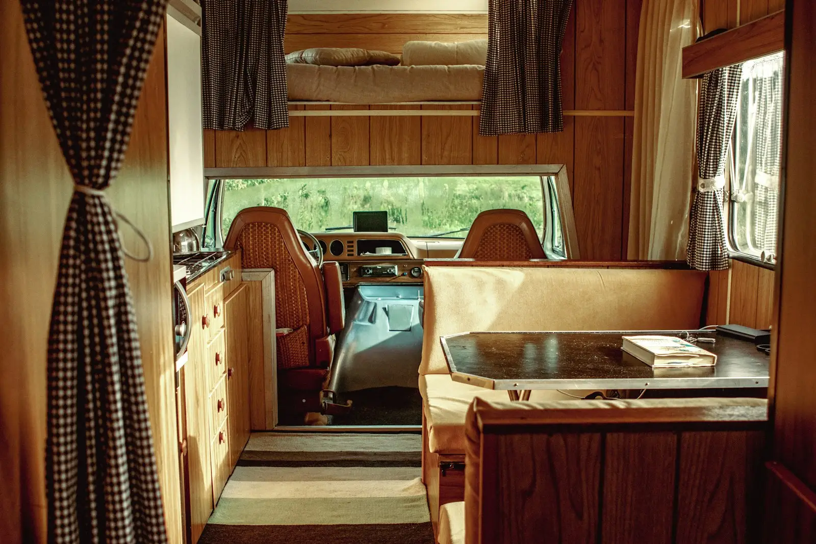 The inside of a camper with a desk and chairs