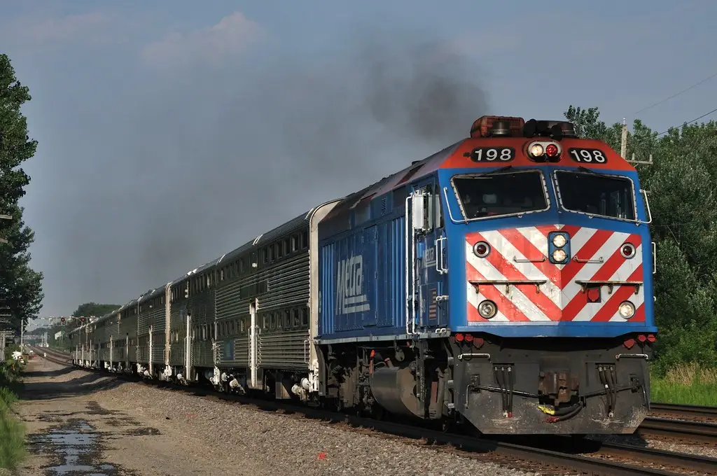 Metra commuter locomotive approaching trackside at speed near a grade crossing in Naperville, Illinois