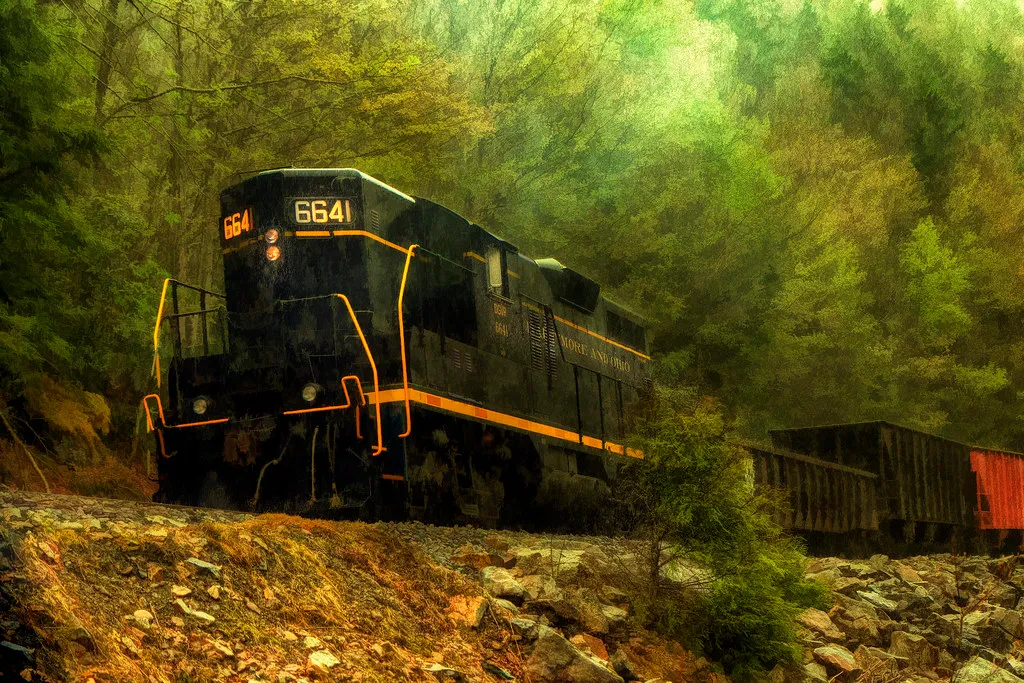 Freight locomotive running westbound through heavy rain