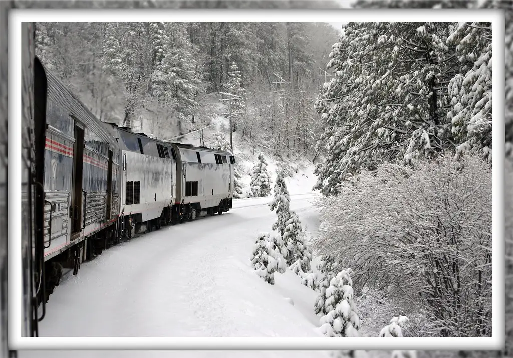 Freight locomotive running through deep snow in the mountains in winter