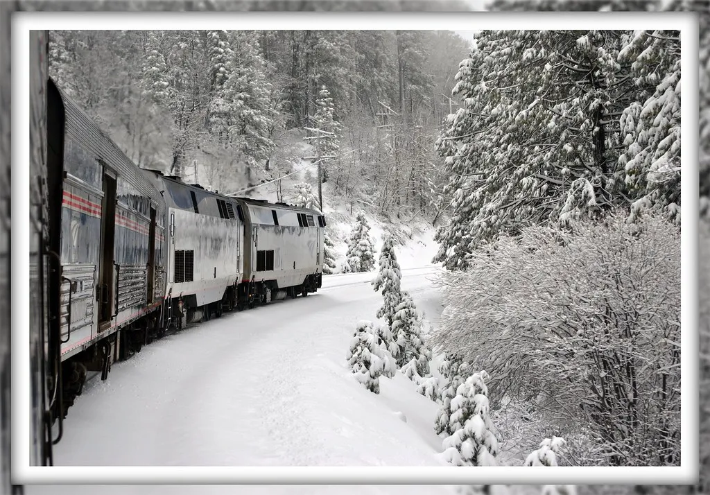 Freight locomotive running through deep snow in the mountains in winter