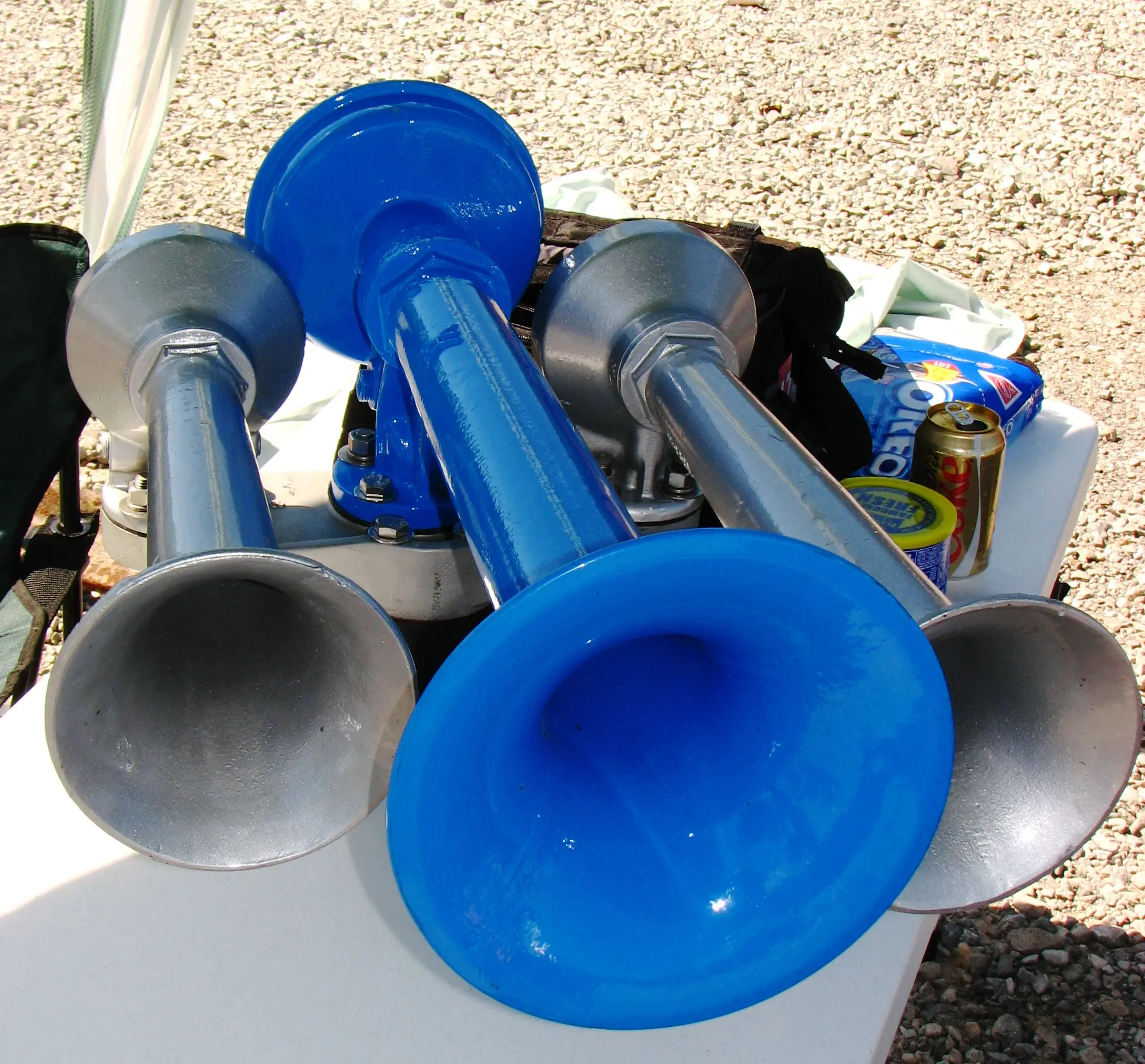 Multi-trumpet locomotive air horn cluster on a mounting flange
