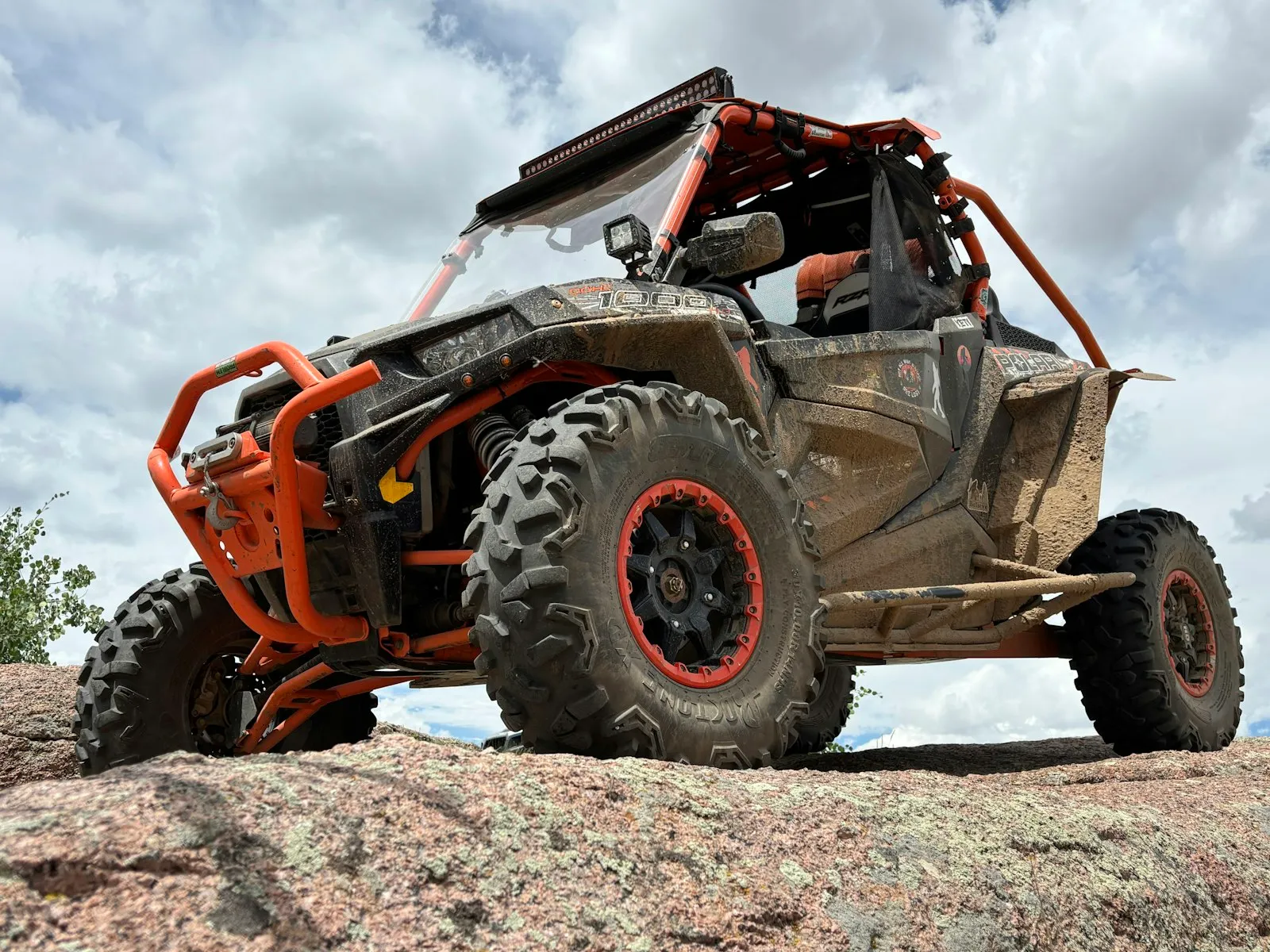 Orange and black off-road UTV on rocks — RZR / side-by-side install context