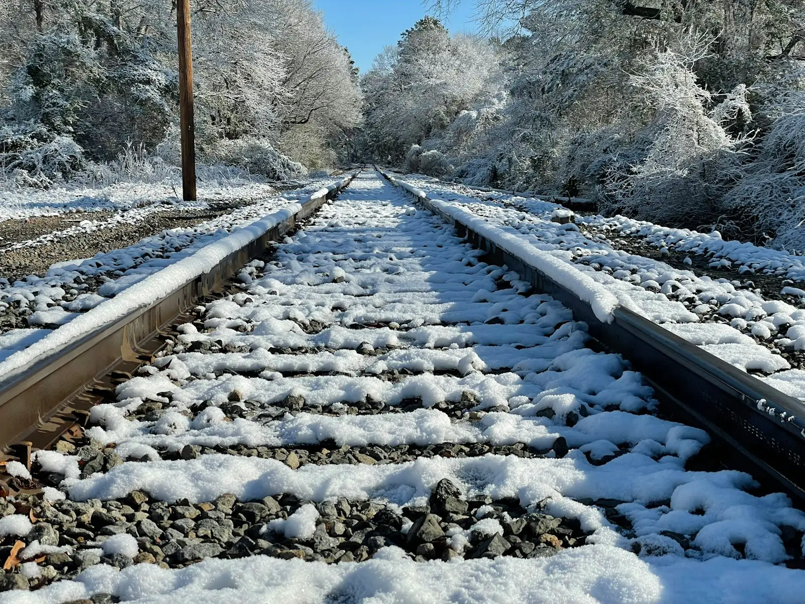 Fresh snow laying on old railroad track.