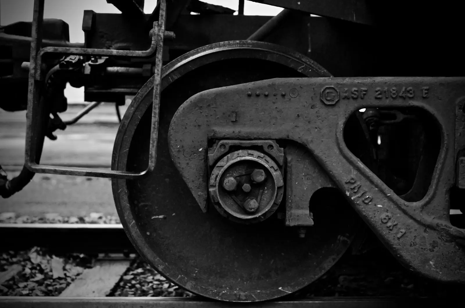 A black and white photo of the wheels of a train