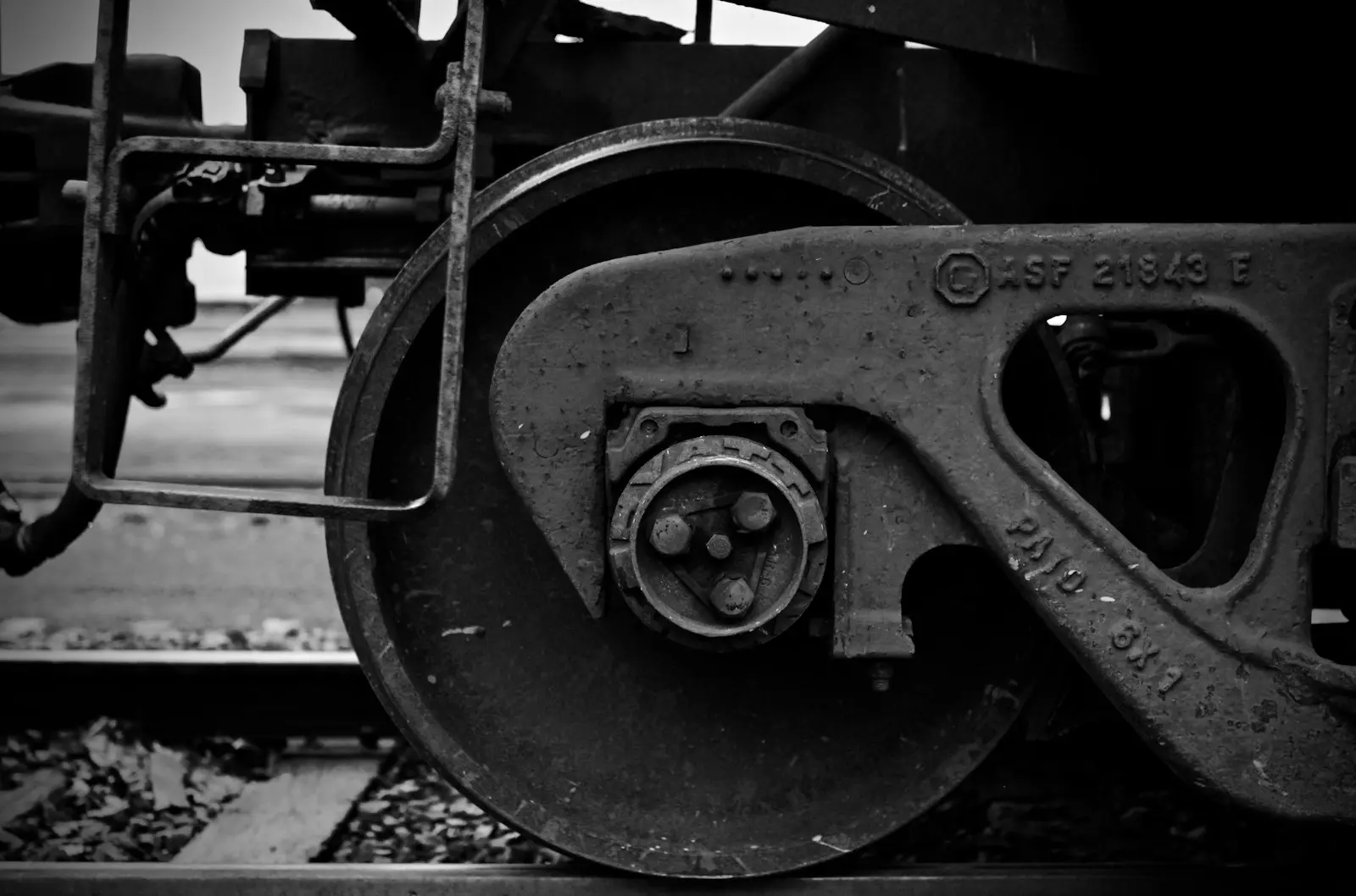 A black and white photo of the wheels of a train