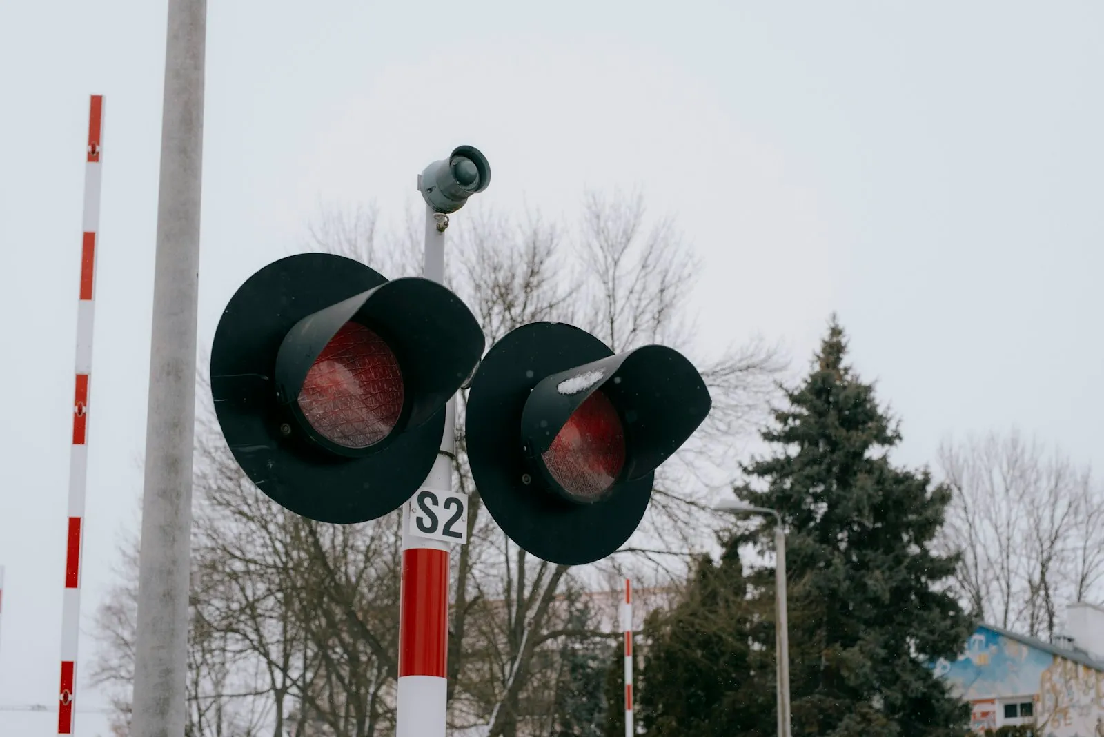Railway crossing signals display a red warning