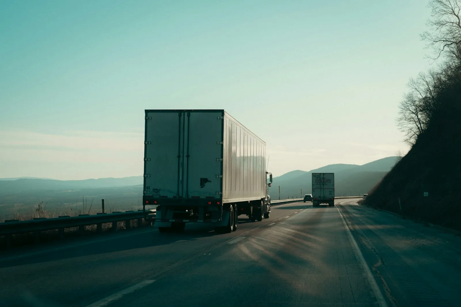 Trucks on a highway road with a mountain view