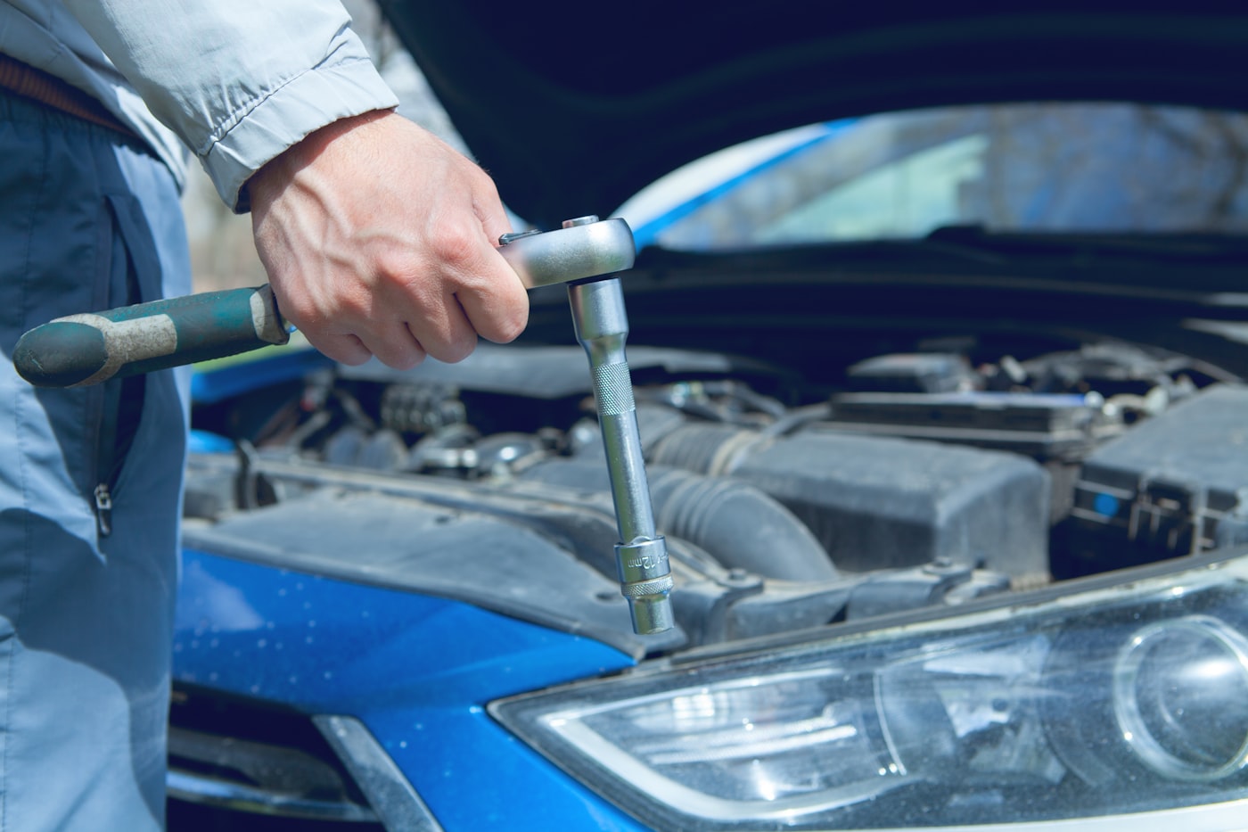 Mechanic using a wrench on a car engine — typical install scenario for the Conductor's 228H 2-gallon kit