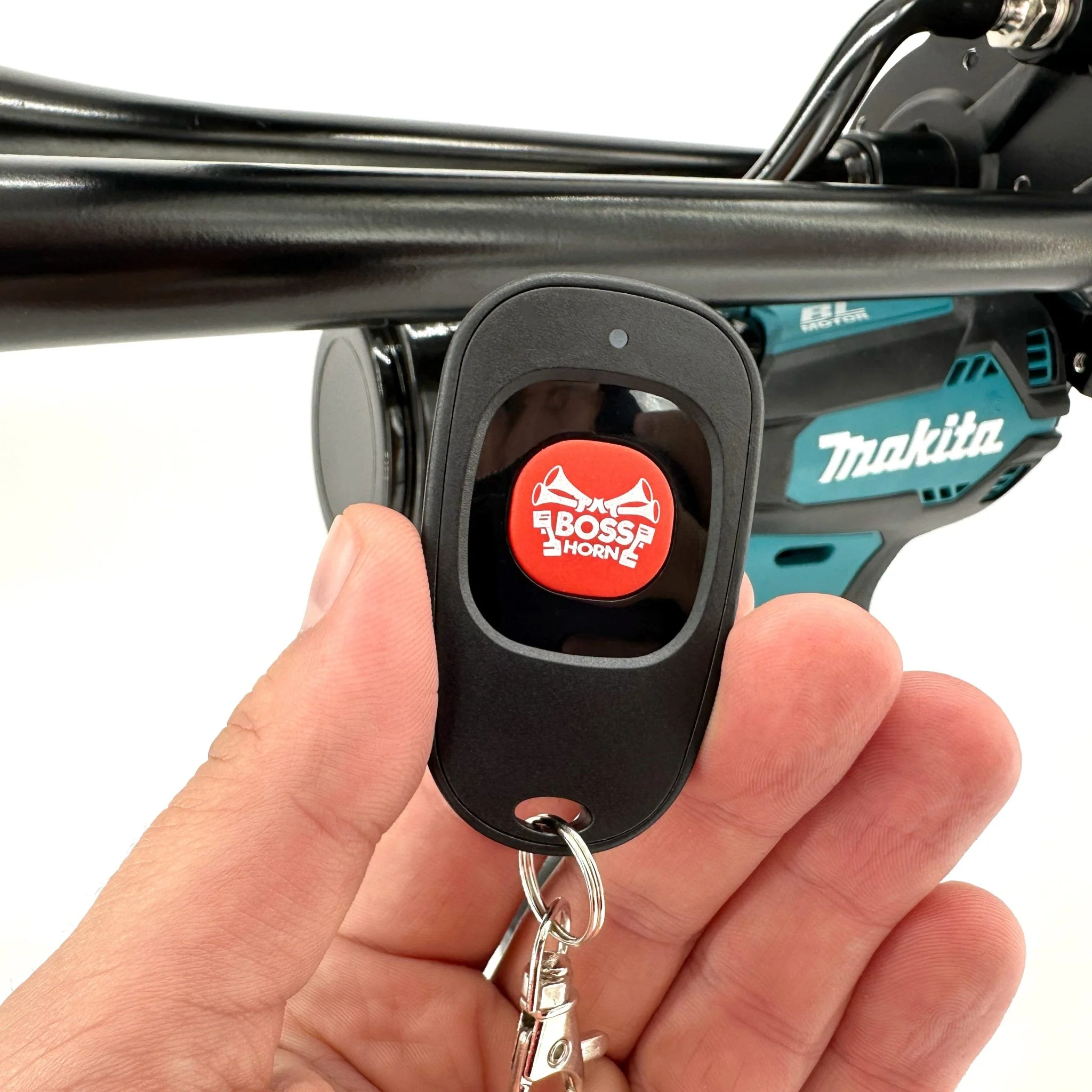Hand holding the BossHorn wireless remote in front of the quad train horn